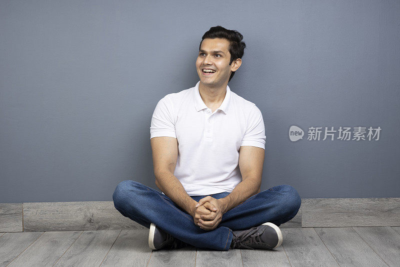 男人盘腿坐在地板上的stock photo